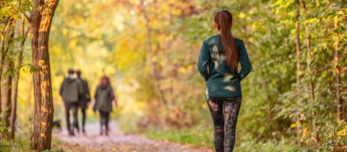 En grupp människor som går längs en stig i skogen.